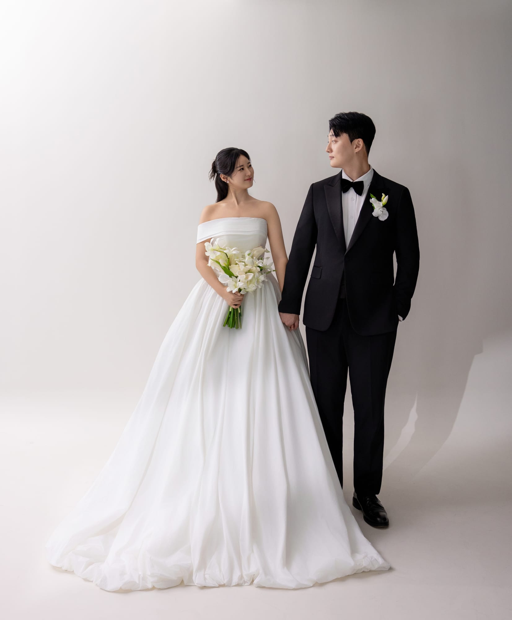 스튜디오에서 손을 잡고 걷는 두 사람